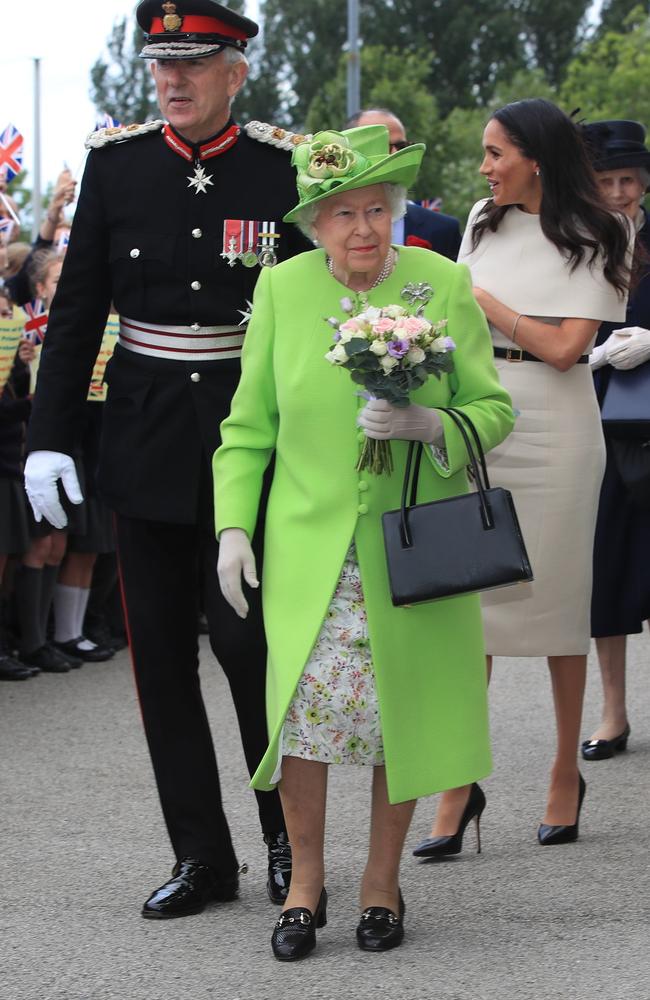 Queen Elizabeth II holds flowers as she and Meghan, Duchess of Sussex, greet the crowds after arriving by Royal Train. Picture: Getty