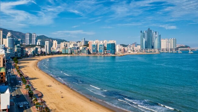 <h2><span>4. Take a dip </span></h2><p><span>At first glance, Haeundae Beach could be the Gold Coast thanks to its glistening skyscrapers looming over the white sand. Stretching over 1.5 kilometres, 10 million locals and visitors are drawn to the placid waters every year. Check out the nearby Haeundae Food Stall Town and Haeundae Traditional Market for affordable bowls of 'gukbap', a spicy rice soup or walk to the end of the beach to Dongbaeksom Island - which is accessible via a bridge and features an enticing nature trail. If you want something a bit more vibey with bars and clubs (day and night), check out the nearby Gwangalli Beach (pictured).</span></p>