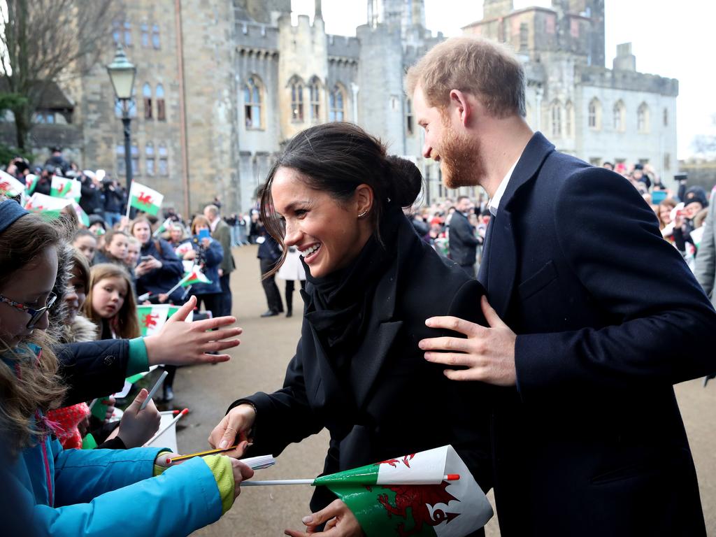 Prince Harry and his fiancee Meghan Markle sign autographs and shake hands with children as they arrive to a walkabout at Cardiff Castle on January 18, 2018 in Cardiff, Wales. .Picture: Getty