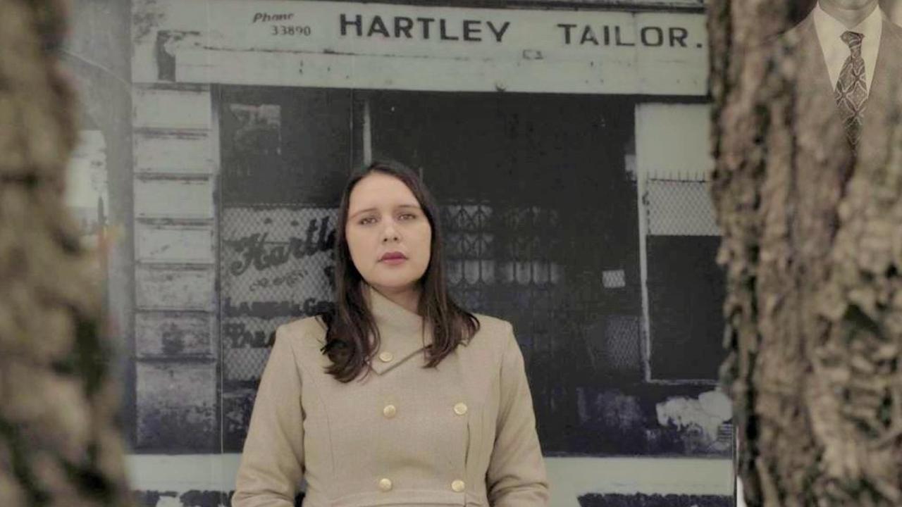 Filmmaker Weaam Williams next to a picture of her family’s long demolished tailor’s shop.