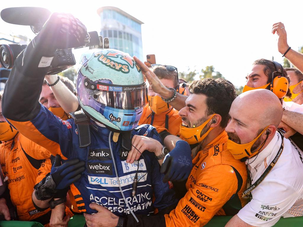 Ricciardo is mobbed by his McLaren team after securing an astonishing win. (Photo by LARS BARON / various sources / AFP)