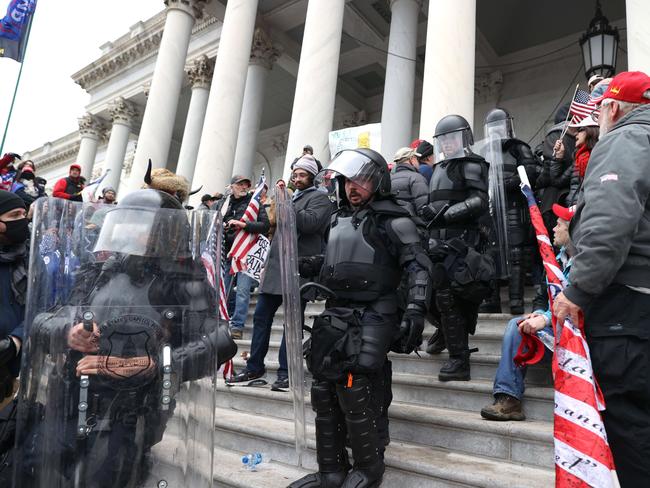 Capitol police officers in riot gear walk through protesters that are gathered on the U.S. Capitol Building. Picture: Getty