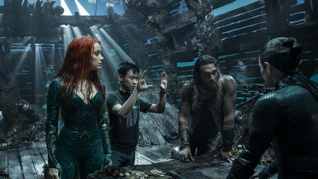 On the Gold Coast set of film Aquaman, James Wan (second from left) directs actors Amber Heard (as Mera), Jason Momoa (Aquaman/Arthur Curry) and Willem Dafoe (back to camera, as Aquaman’s mentor Vulko) inside a sunken Spanish galleon. Picture: Warner Bros Pictures.