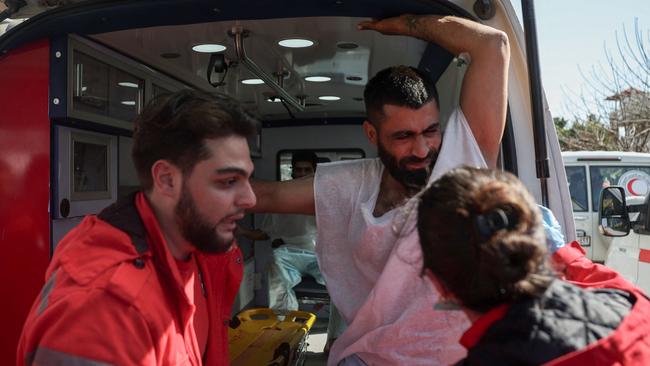 Syrian Red Crescent members evacuate wounded civilians who took refuge from violence in the Hmeimim Russian base in Syria on Tuesday. Picture: AFP