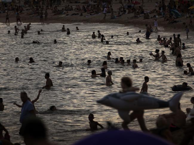 People swim in the sea during a hot summer day in Barcelon. Picture: Emilio Morenatti