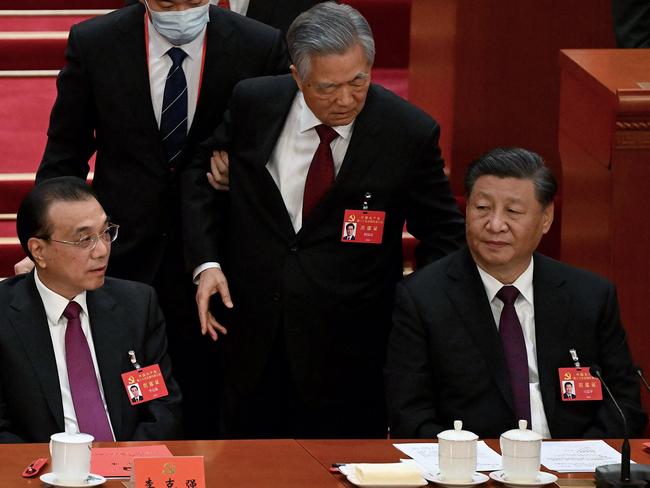 TOPSHOT - China's President Xi Jinping (R) sits besides Premier Li Keqiang (L) as former president Hu Jintao (C) is assisted to leave from the closing ceremony of the 20th China's Communist Party's Congress at the Great Hall of the People in Beijing on October 22, 2022. (Photo by Noel Celis / AFP)