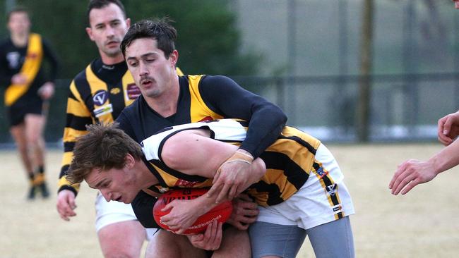 Jordan Tailby of Upwey Tecoma is tackled by Jordan Williams of Woori Yallock Picture: Hamish Blair