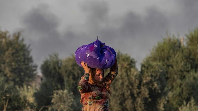 A woman flees from the atack on Ras al-Ain.Picture: AFP.