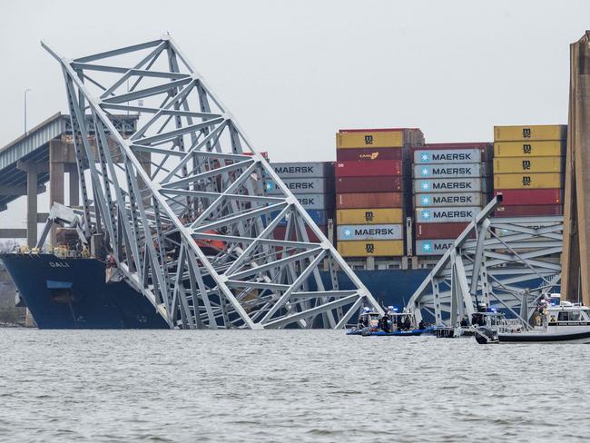 The collapsed Francis Scott Key Bridge lies on top of the container ship Dali in Baltimore. Emergency services are searchingfor six missing men. Picture: AFP