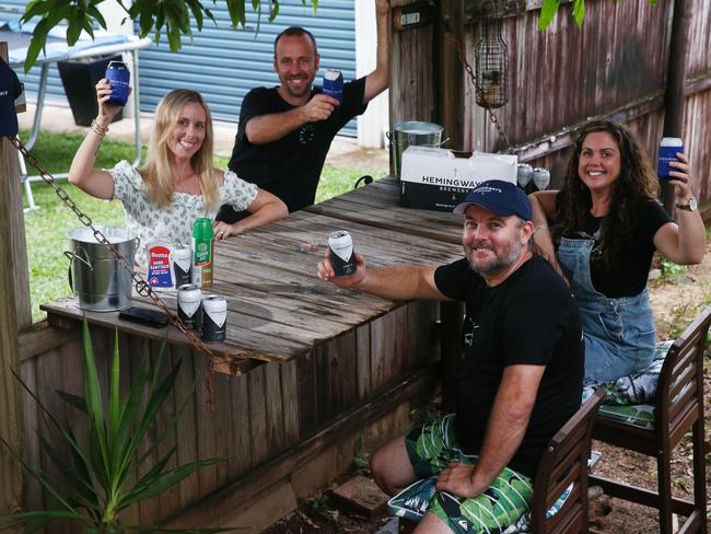 Woree handiman Darryl Strugnell decided to build a bar into his fence so both he and his wife Louise can have drinks with the neighbours. Carly and Stephen Parsons and Darryl and Louise Strugnell toast their drinks at the COVID Bar. PICTURE: BRENDAN RADKE.