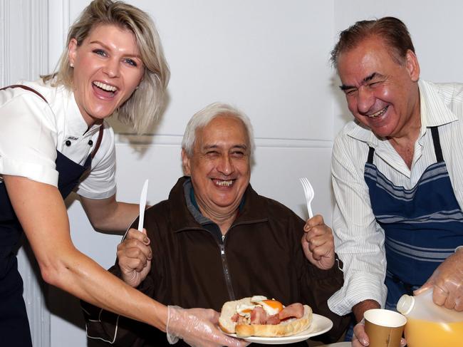 Courtney Roulston ( Former Masterchef contestant )and Rocky Massaria (CEO Club York ) serve up a hot breakfast to George (client) at The Station Drop In centre in Sydney. Picture: Craig Wilson