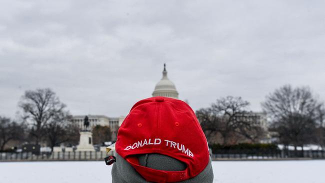 A man wearing a Trump hat looks at the US Capitol. Picture: AFP