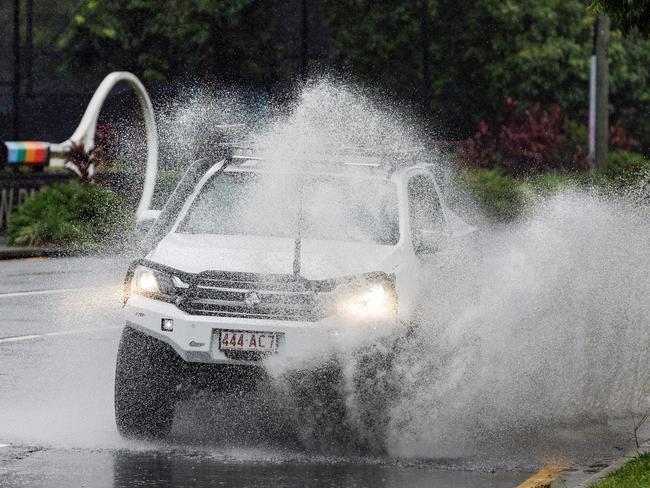A car drives through flash flooding at Milton. Picture Lachie Millard