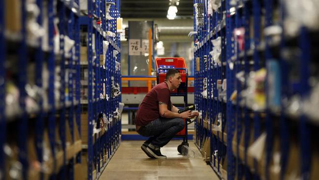 An employee selects goods from storage units ahead of packaging for delivery at Amazon.co.uk Photo: Simon Dawson/Bloomberg