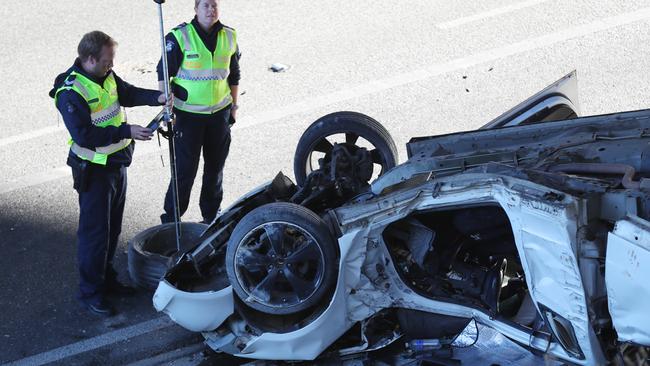 Police investigate after a ute crashed while racing with another car that did not stop. Picture: David Crosling