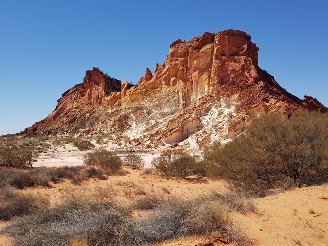 A rocky outcrop cuts a stark shape against a clear blue sky in Rainbow Valley. Picture: Craig Humphris