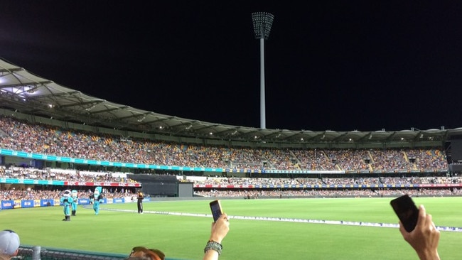 Fans at the Gabba use their phones to try to shed some light on the matter. Picture: John O'Brien