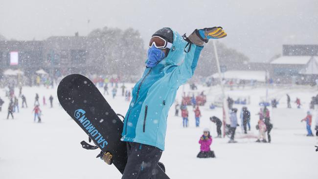 Snow falls for a snowboarder.