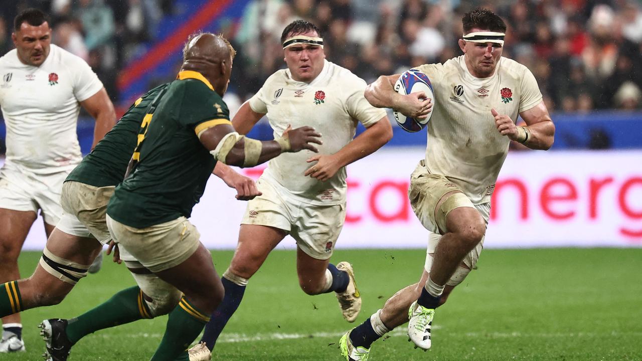 England's openside flanker Tom Curry (R) runs with the ball during the France 2023 Rugby World Cup semi-final match between England and South Africa at the Stade de France in Saint-Denis, on the outskirts of Paris, on October 21, 2023. (Photo by Anne-Christine POUJOULAT / AFP)