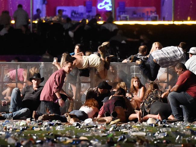 People climb over walls to shelter from the gunman. Picture:  David Becker/Getty Images/AFP