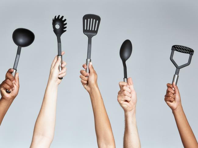 Group of keen cooks holding up a variety of kitchen implements, including ladle, spaghetti lifter, spatula, serving spoon and potato masher.