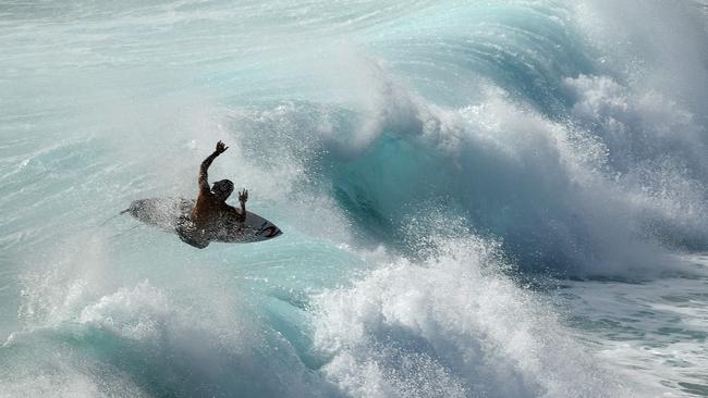 A surfer is seen at Duranbah, the northernmost beach in New South Wales, Thursday February 21, 2019. Huge swells and high tides are set to pummelling south-east Queensland and far-northern New South Wales beaches over the coming days as Cyclone Oma tracks towards the Queensland coast. Photo: Dave Hunt/AAP.