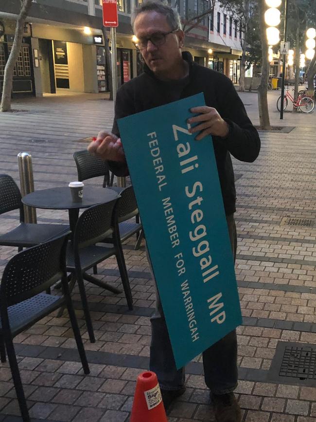 Matt Wiles, from Absolute Sign Solutions at Brookvale, prepares to replace the Tony Abbott signs. Picture: Jim O’Rourke.