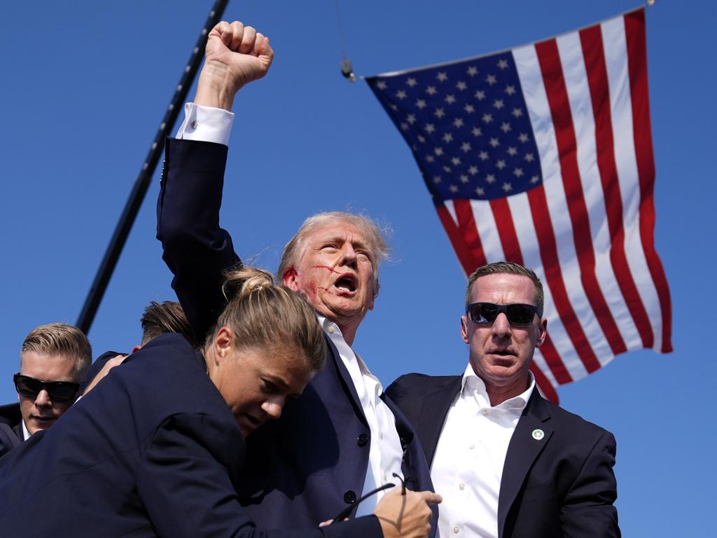 <p>Who could forget this moment? Donald Trump surrounded by U.S. Secret Service agents at a campaign rally after a bullet skimmed his ear in July, before he was once again voted back in as President. Picture: AP Photo/Evan Vucci</p>