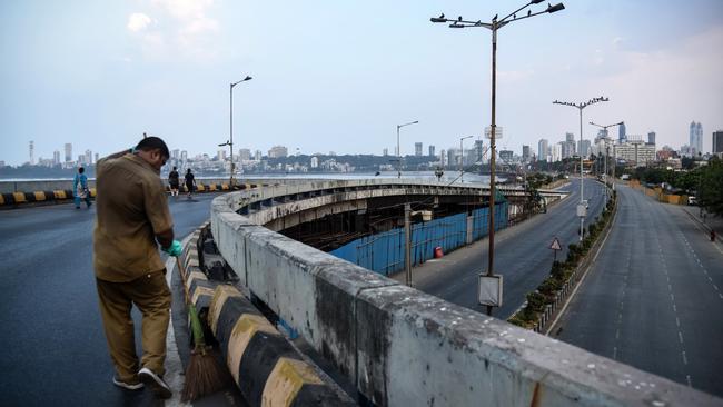 A worker sweeps a stretch of deserted road in Mumbai. Picture: Fariha Farooqui/Getty Images