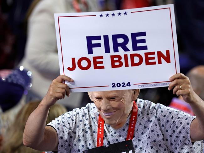 An attendee wearing a US President Joe Biden mask holds a sign during the last day of the 2024 Republican National Convention at the Fiserv Forum in Milwaukee, Wisconsin, on July 18, 2024. Donald Trump will get a hero's welcome Thursday as he accepts the Republican Party's nomination to run for US president in a speech capping a convention dominated by the recent attempt on his life. (Photo by Kamil Krzaczynski / AFP)