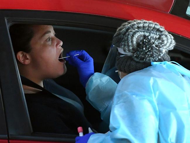 Medical workers staff a drive-through Covid-19 testing site located in a shopping centre carpark in Melbourne on June 23, 2020. - Australians were warned on June 22 to avoid travelling to Melbourne, as the country's second biggest city tightened coronavirus restrictions amid fears of a second wave of the epidemic. (Photo by William WEST / AFP)