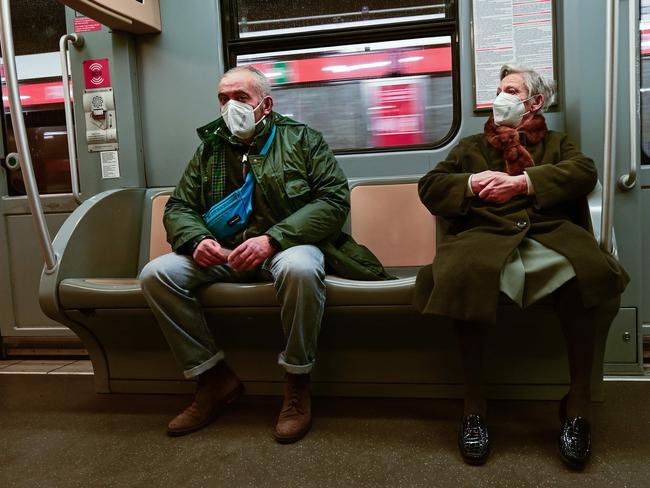 Commuters wearing protective masks sit in one of Milan's trains. Masks in transport, stadiums, movie theatres, museums and sporting events is now mandatory in Italy. Picture: AFP