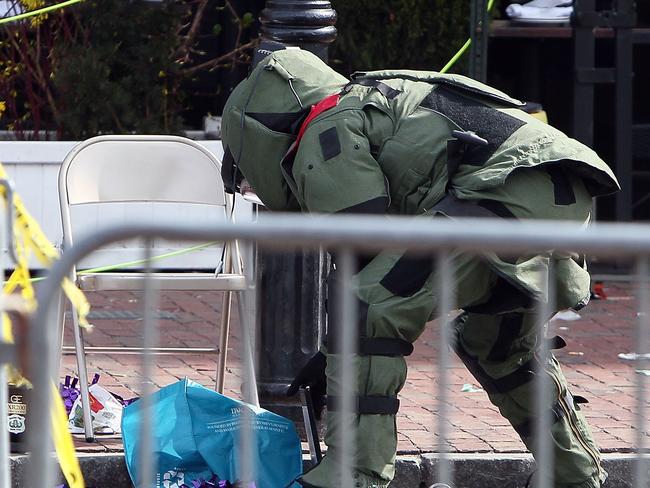 BOSTON, MA - APRIL 15: A member of the bomb squad investigates a suspicious item on the road near Kenmore Square after two bombs exploded during the 117th Boston Marathon on April 15, 2013 in Boston, Massachusetts. Two people are confirmed dead and at least 23 injured after two explosions went off near the finish line to the marathon. Alex Trautwig/Getty Images/AFP== FOR NEWSPAPERS, INTERNET, TELCOS & TELEVISION USE ONLY ==