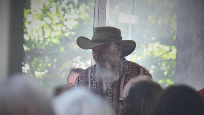 Uncle Mark Flanders walks through the crowd during a smoking ceremony at Australia Day 2021. Photo: Tim Jarrett