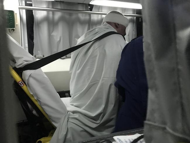 A man with a bandaged head is taken away in an ambulance after yesterday’s raid in Surry Hills. Picture: Dylan RobinsonSource: Supplied