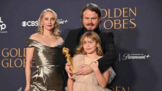 Brady Corbet poses with the award for Best Director trophy for The Brutalist with Norwegian director, screenwriter Mona Fastvold and daughter Ada at the 82nd annual Golden Globe Awards. Picture: Robyn Beck/AFP