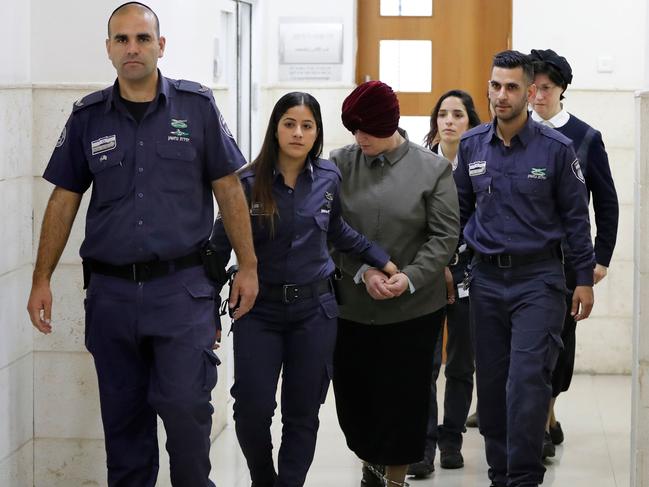 Malka Leifer (C), a former Australian teacher accused of dozens of cases of sexual abuse of girls at a school, is escorted by police. Picture: AFP