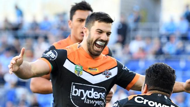 West Tigers player James Tedesco celebrates after Esan Nike Marsters scored a try.