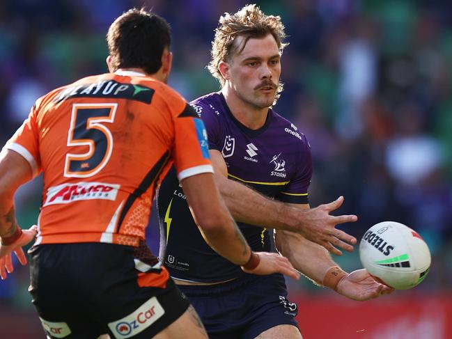 MELBOURNE, AUSTRALIA - MAY 11: Ryan Papenhuyzen of the Storm passes the ball during whilst under pressure from Charlie Staines of the Tigers the round 10 NRL match between Melbourne Storm and Wests Tigers at AAMI Park, on May 11, 2025, in Melbourne, Australia. (Photo by Mike Owen/Getty Images)
