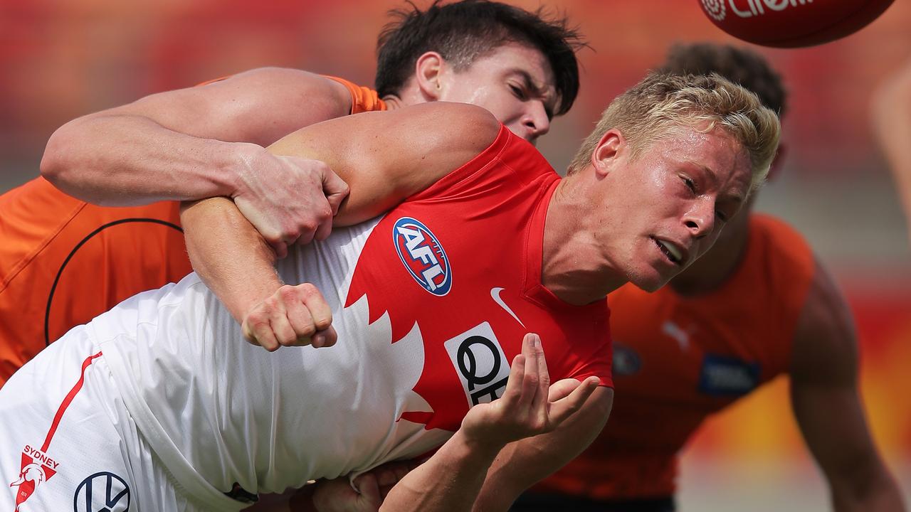 Isaac Heeney gives off a handball under pressure.