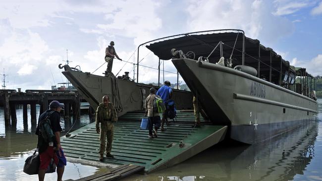 Manus Island processing centre staff board a landing craft for transfer to HMAS Choules.