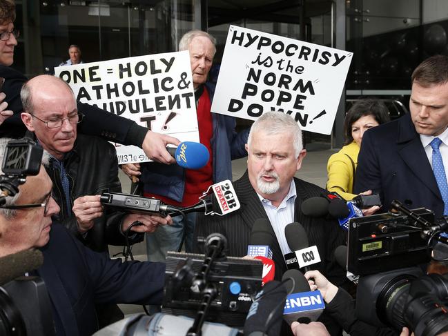 Protesters flanked victims’ advocate Peter Gogarty as he spoke outside the Newcastle Local Court on Tuesday. AAP Image/Darren Pateman