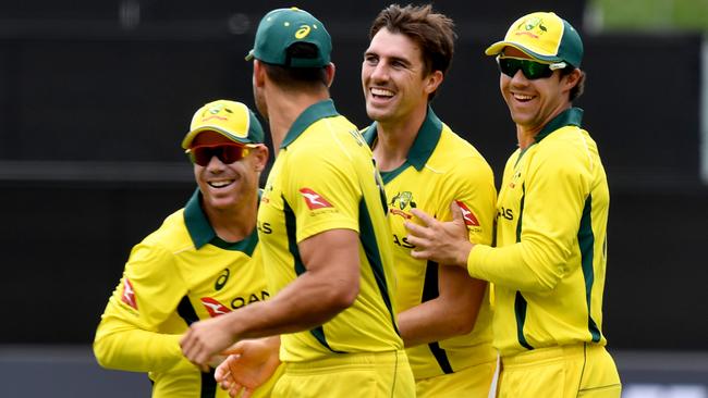 David Warner, Pat Cummins, and Travis Head celebrate the wicket of Joe Root. AAP Image/Sam Wundke