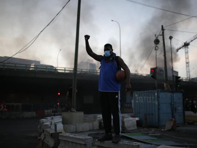 A protester holding a basketball raises his fist during a demonstration in Paris. Picture: Rafael Yaghobzadeh