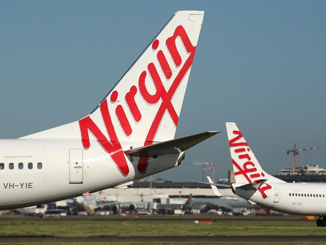 The Virgin Australia Holdings Ltd. logo is displayed on the tails of a Boeing Co. 737-800, left, and a Boeing Co. 737-8FE aircraft preparing to take off at Sydney Airport in Sydney, Australia, on Monday, Feb. 8, 2016. Virgin Australia is scheduled to announce half-year earnings on Feb. 11. Photographer: Brendon Thorne/Bloomberg