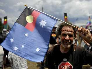 AUSTRALIA DAY DEBATE: A man hold a flag where the Aboriginal flag replaces the Union Jack during a protest on Australia Day, Friday, January 26, 2018. Picture: MICK TSIKAS