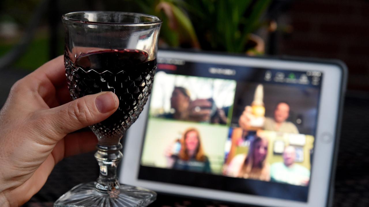 A woman lifts her glass and cheers with friends during a virtual happy hour amid the coronavirus pandemic. Picture: Olivier Douliery / AFP