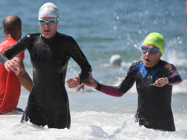 Katie Kelly and guide Michellie Jones emerge from the water after the swim leg.