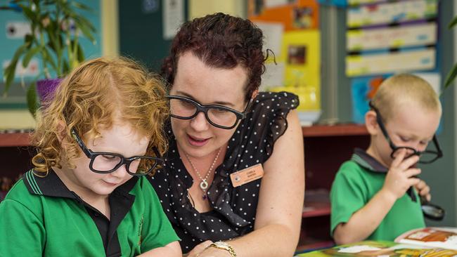 Berry Springs Preschool teacher Carla Hayes helps Ruby during class.