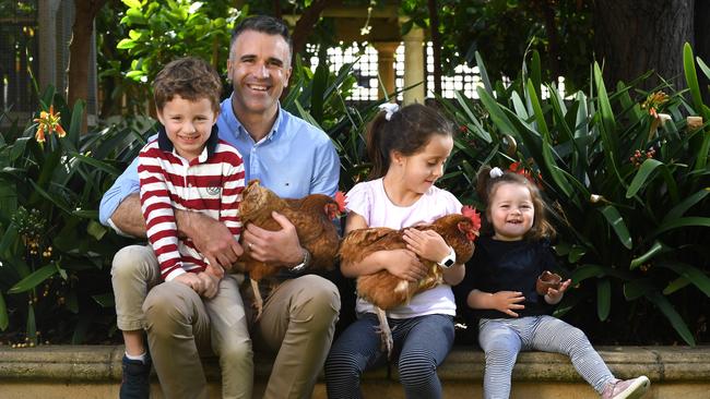 Peter Malinauskas with Jack, 4, Sophie 6, Eliza, 18 months, and pet chooks Sarah and Poppy. Picture: Tricia Watkinson